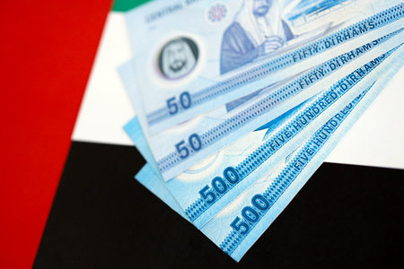United Arab Emirates dirham currency money bills lies on flag close up. The concept of business and investmentの写真素材