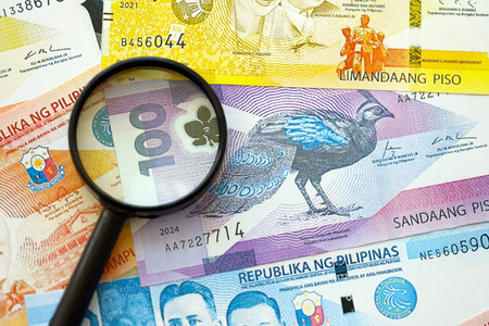 Philippines peso currency money bills and magnifying glass close up. The concept of financial monitoring and taxationの写真素材