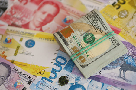 Philippines peso currency money bills and bunch of us dollar banknotes close up. The concept of economics and currency exchangeの写真素材