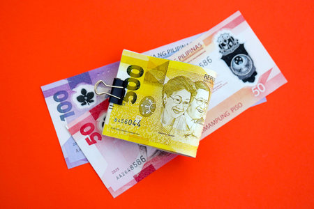 Philippines peso money bills in big amount close up on red. Finance and banking concept