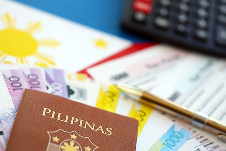 Philippines peso money bills and calculator with tax form on flag close up. Taxation and accounting conceptの写真素材