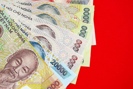 Vietnamese dong money bills in big amount close up on red. Finance and banking conceptの写真素材