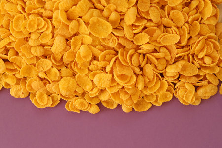 Background of breakfast cereals in big amount on purple background close up, top view