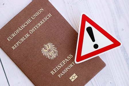 Austria passport with exclamation sign on white wooden background close up. Problems with citizenship in Europe conceptの写真素材