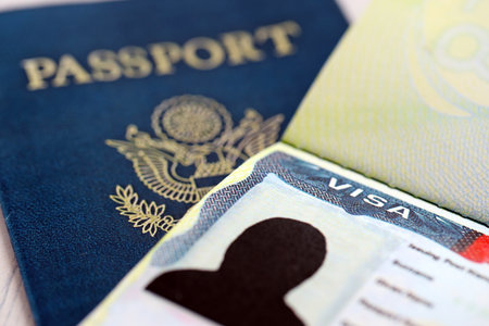 USA visa in an open passport page and United States passport cover on background close up