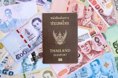 Thai baht currency money bills and passport close up. The concept of travel and vacationの写真素材