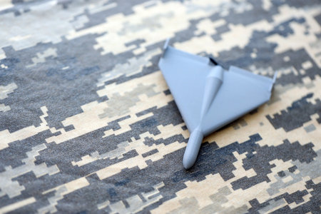 Unnamed grey toy drone model on camouflage fabric close up.の写真素材