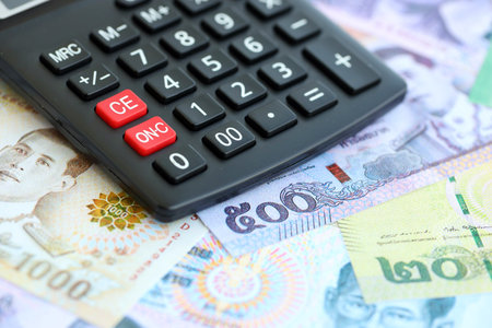 Thai baht currency money bills and calculator close up. The concept of taxation and money count