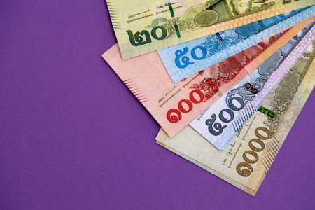 Thai baht money bills in big amount on purple close up. Finance and banking concept