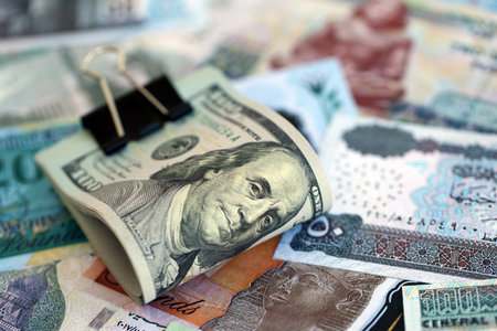 Egyptian pound currency money bills and bunch of us dollar banknotes close up. The concept of...
