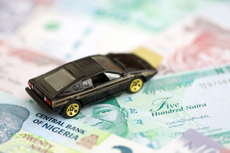 Nigerian naira currency money bills and toy car close up. The concept of car ownership