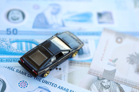 United Arab Emirates dirham currency money bills and toy car close up. The concept of car ownership