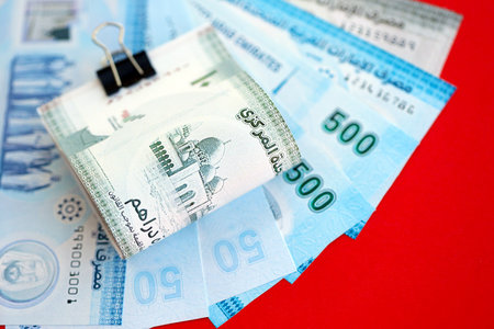 United Arab Emirates dirham money bills in big amount close up on red. Finance and banking conceptの写真素材