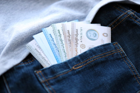 United Arab Emirates dirham money bills in denims pocket close up. The concept of fashion and wealthの写真素材