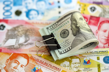 Philippines peso currency money bills and bunch of us dollar banknotes close up. The concept of economics and currency exchangeの写真素材