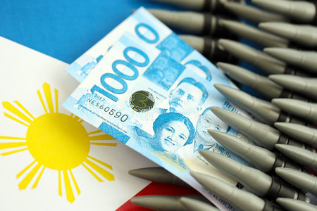 Philippines peso currency money bills and rifle bullets on flag close up.の写真素材