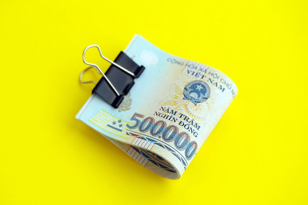 Vietnamese dong money bills in big amount close up on yellow. Finance and banking conceptの写真素材
