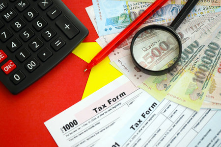 Vietnamese dong money bills and calculator with tax form on flag close up. Taxation and accounting conceptの写真素材