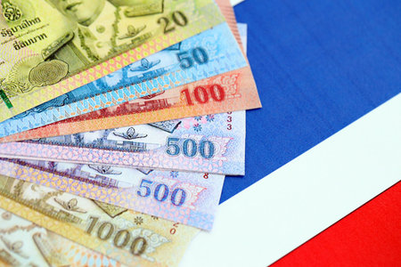 Thai baht currency money bills lies on flag close up. The concept of business and investmentの写真素材