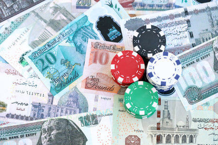 Egyptian pound currency money bills and bunch of casino chips close up. The concept of gambling and casino gamesの写真素材