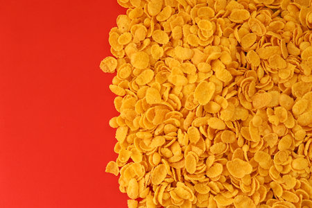 Background of breakfast cereals in big amount on red background close up, top view