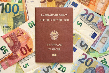 Austria passport lies on big amount of euro money banknotes close up. Travel in Europe conceptの写真素材