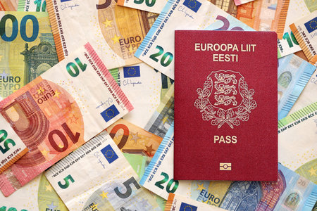 Estonia passport lies on big amount of euro money banknotes close up. Rich life and travel in Europe conceptの写真素材