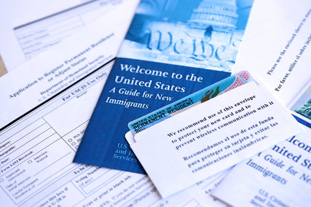 Permanent resident green card in envelope with application and guide for new immigrants lies on table close upの写真素材