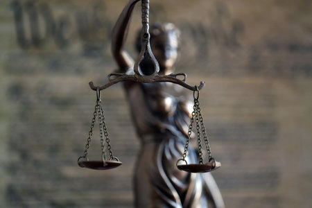 Lady Justice and background of US Constitution page close up. Lawsuit and judgement in United States of Americaの写真素材