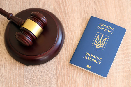 Judge gavel and ukrainian passport on brown background. Passport Of Ukraine. Obtain citizenship