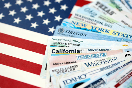 Big amount of driving licenses from different USA states on flag close up. Stack of driving license specimen cardsの写真素材