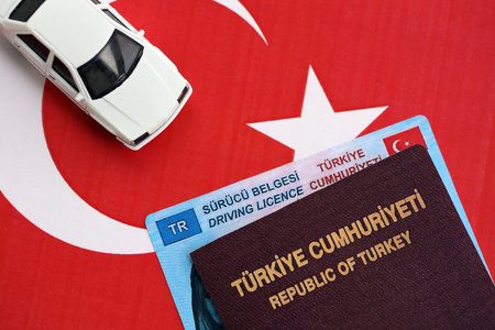 Turkiye driving permit concept. Driver license with passport and toy car on turkish flag close upの写真素材