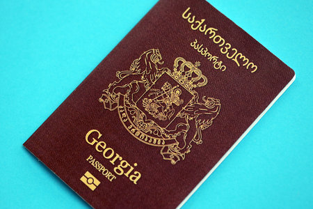 Georgian passport book on light blue paper background close up. Travel document on blue surfaceの写真素材