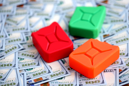 Gasoline canister lies on big amount of dollar bills. Concept of petrol pricesの写真素材