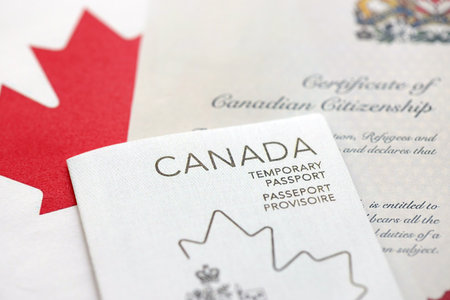 Canadian temporary passport and certificate of citizenship lies on flag close upの写真素材