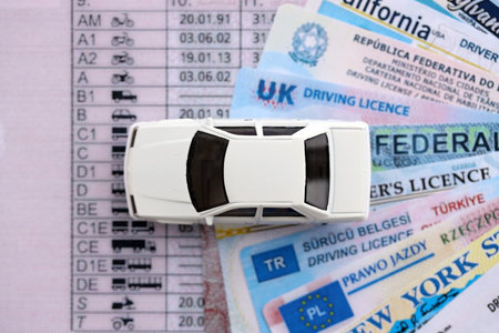 Toy car on driving licenses from different countries and American states. Concept of obtaining driving permitの写真素材
