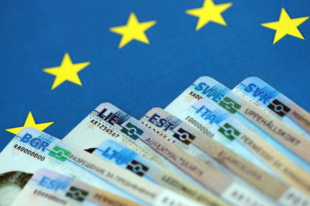 Permanent resident or residence permit cards lies on European Union flag. Paper specimen cards close upの写真素材