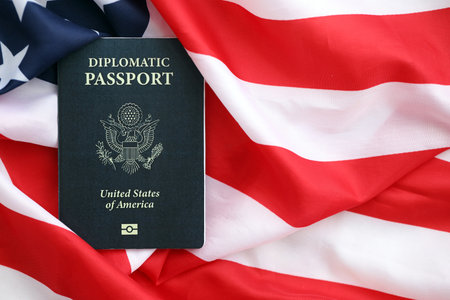 United States diplomatic passport book on US flag close up. Travel document on official banner photoの写真素材