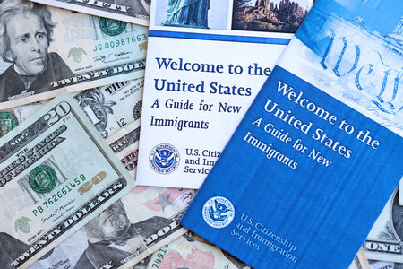 Permanent resident green card holders guide for new immigrants lies on many dollar bills close up