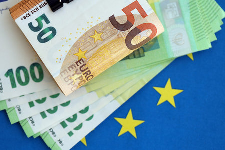 European euro currency money notes bunch on Europe union blue flag close up. Concept of business and...