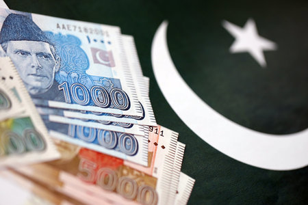 Pakistan rupees banknotes on Pakistani flag background. The current Pakistan money bills lies on banner in big amount. The concept of economics and business in Pakistanの写真素材