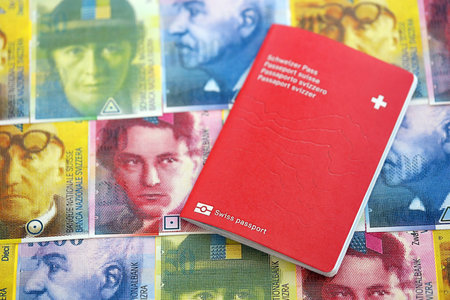 Swiss franc banknotes and passport. The current francs money bills and biometrical pass lies on table. The concept of travel and vacation in Switzerlandの写真素材