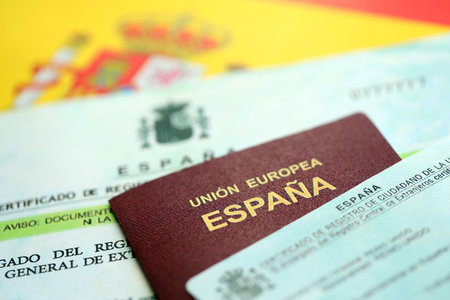 Spanish passport lies on citizenship or naturalization documents on flag of Spain close upの写真素材