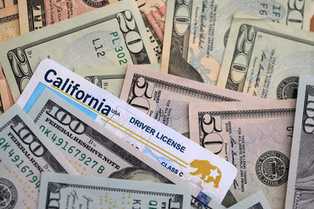 California state driving license among big amount of US dollar bills close upの写真素材