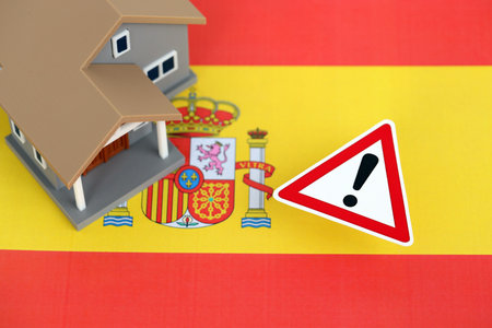 Residential house with alert sign on Spanish flag close up. Concept of Squatting in Spain. Okupas problemの写真素材