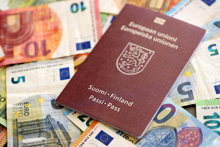 Finland passport lies on big amount of euro money banknotes close up. Rich life and travel in Europe conceptの写真素材