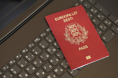 Estonia passport lies on black laptop keyboard buttons background close up. Technologies and control in Europe conceptの写真素材
