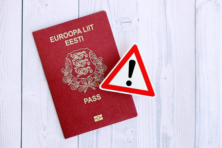 Estonia passport with exclamation sign on white wooden background close up. Problems with citizenship in Europe conceptの写真素材
