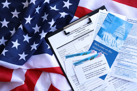 Permanent resident green card in envelope with application and guide for new immigrants lies on US flag close upの写真素材