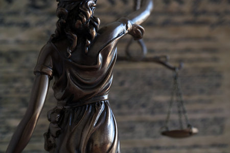 Dark scene with Lady Justice and US Constitution page close up. Lawsuit and judgement in United States of Americaの写真素材